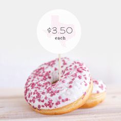 two donuts with pink sprinkles are on a white sticker that says $ 3 50 each