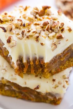 two pieces of carrot cake sitting on top of a white plate