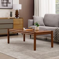 a living room with a couch, coffee table and side tables in front of a window