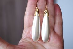 "VINTAGE 14K GF GOLD LARGE WHITE TEAR DROP MAJORCA  PEARL Fish Hook  EARRINGS  BEING OFFERED IS A FABULOUS 14K 72 MM LARGE GOLDEN / WHITE MAJORCA PEARLS PERFECT TEAR DROP WHITE / GOLDEN MAJORCA PEARL EARRINGS THESE EARRINGS ARE NEW OLD STOCK PEARLS THEY ARE MAJORCA FROM SPAIN THEE EARRINGS ARE VERY LIGHT WEIGHT WITH EXCELLENT COATING 7.6 GRAMS MAJORCA PEARLS ARE FAMOUS \" MAN MADE \" CREATED PEARLS IN SPAIN WITH PEARL  COATING. THEY ARE NEW OLD STOCK FROM HOBE COMPANY. I HAVE FEW PAIRS. PLESAE S High Luster Baroque Pearl Teardrop Earrings, Tarnish-resistant Yellow Gold Teardrop Pearl Earrings, White Teardrop Baroque Pearl Earrings, Vintage Brass Pearl Drop Earrings, 14k Gold-filled Pearl White Drop Earrings, T Bag, Big Pearl, Retro Earring, Majorca