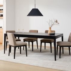 a dining room table and chairs in front of a white rug