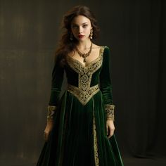 This dress pays homage to the grandeur of the Renaissance era with its lush emerald green velvet. The square neckline is embellished with elaborate gold embroidery, reminiscent of the intricate patterns found in historical royal attire. The fitted bodice accentuates the queen's silhouette, while the sleeves boast intricate lace insets. The skirt, flowing gracefully to the floor, is adorned with emerald and gold brocade, adding an extra layer of opulence. Green And Gold Dress Gown, Green Medieval Dress, Midevil Dress, Green And Gold Dress, Royal Gowns, Turquoise Dress, Queen Dress, Medieval Dress