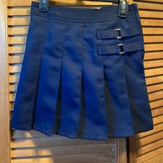 Navy Blue Uniform Approved Skirt With Pleated Bottom, Decorative Straps On The Left Front, A Zipper On The Side, Attached Boy Shorts, And Adjustable Elastic Waistband Inside. Size 7 Youth. 100% Polyester. Nwot School Uniform Lined Skirt, High Waist Blue Mini Skirt With Belt Loops, School Mini Skirt With Pockets, School Mini Skirt With Lining, Fitted Tennis Skirt With Pockets For School, Blue Pleated Skirt For School In Spring, Blue Denim Mini Skirt With Belt Loops, Casual Blue Mini Skirt With Belt Loops, School Uniform Tennis Skirt In Mini Length