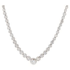 Vintage 18 karat white gold bezel set diamond Riviera necklace with 39 round brilliant cut diamonds, G-I in color VS2-SI1 in clarity. Stones are graduated throughout the necklace. The necklace measures approximately 16" with safety clasp. Diamond Riviera necklaces have long been considered a strong cornerstone of any jewelry collection. Composed only of diamonds and white gold, this is a necklace that can one day be worn over a white tank top or on an evening gown the next. Truly a piece of jewe Riviera Necklace, Bezel Set Diamond, White Tank Top, White Tank, Round Brilliant Cut Diamond, Brilliant Cut Diamond, Bezel Setting, Evening Gown, Round Brilliant