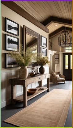 a living room with pictures on the wall and a rug in front of an entryway