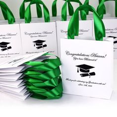 green ribbons are tied around white bags with graduation caps on them and congratulations cards in the center