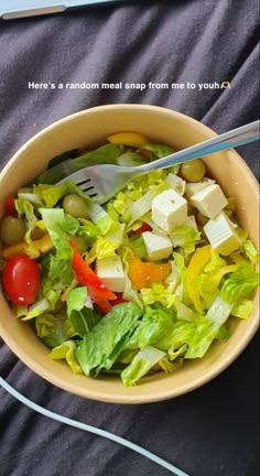 a salad in a bowl with a fork and knife