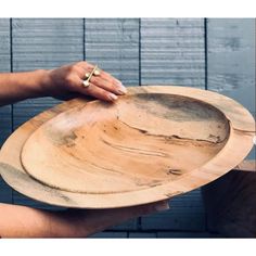 a person holding a wooden plate in their hand