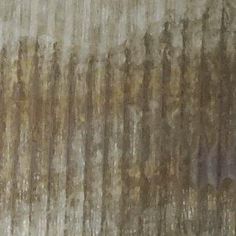 the wall is covered in brown and white paint with streaks of light coming from it