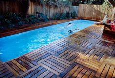 a wooden deck next to a swimming pool