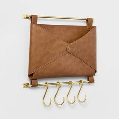 an envelope hanging on a wall with three hooks attached to it and two pairs of scissors