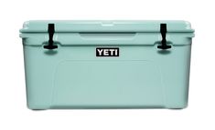 a blue yeti cooler with black handles on the front and bottom, against a white background