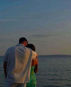 a man and woman looking out at the ocean