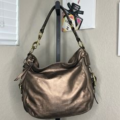 Coach Euc Bronze Leather Purse, Hardly Used, With Inside Pockets. Height: 12” Length: 12” Width: 4.5” Elegant Gold Hobo Bag, Elegant Gold Hobo Bag With Metal Hardware, Elegant Evening Hobo Bag With Brass Hardware, Coach Gold Shoulder Bag With Metal Hardware, Gold Coach Shoulder Bag With Metal Hardware, Elegant Hobo Bag With Brass Hardware For Daily Use, Elegant Coach Hobo Bag With Branded Hardware, Elegant Coach Hobo Bag For Formal Occasions, Elegant Coach Hobo Bag With Silver-tone Hardware