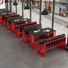 tables and benches are lined up in the middle of an empty building with black lamps hanging over them