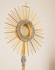 a gold and diamond sunburst hanging on a wall