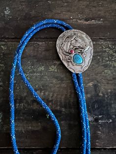 "Awesome vintage bolo tie Silver metal Nice weight Cool design  Faux stones  Blue and silver cord 34\"  Great condition!!  Shipped priority mail" Blue Lariat Bolo Tie For Gift, Southwestern Blue Bolo Tie For Gift, Southwestern Blue Bolo Ties As A Gift, Silver Bohemian Bolo Tie With Adjustable Cord, Blue Handmade Bolo Tie Gift, Bohemian Turquoise Lariat Bolo Tie, Bohemian Silver Handmade Bolo Tie, Handmade Silver Bohemian Bolo Ties, Vintage Turquoise Bolo Ties For Rodeo