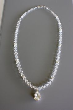 This will go well with a beaded gown to pick up those crystal accents.  It is very reflective and will sparkle throughout your special day.  This bridal necklace is made of Swarovski crystals and a large tear drop Swarovski rhinestone pendant.  It can be made to any length but this one measures 17 inches. Check out the matching Earrings:  https://www.etsy.com/listing/92769395/rhinestone-and-crystal-bridal-earrings  Check out the matching Bracelet https://www.etsy.com/listing/92769908/simple-crystal-and-rhinestone-bridal Elegant White Crystal Necklaces With Rhinestones, Elegant White Crystal Necklace With Rhinestones, Elegant Crystal Beaded Necklaces With Clear Beads, White Rhinestone Necklace With Sparkling Crystal Stones, White Crystal Rhinestone Necklace With Sparkling Stones, Elegant Clear Beaded Crystal Necklaces, Elegant Beaded Clear Crystal Necklace, White Rhinestone Necklace With Sparkling Crystals, Elegant Clear Crystal Beaded Necklaces