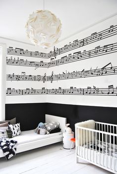 a room with musical notes on the wall and a crib in the foreground