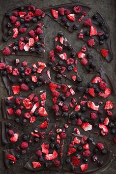 a chocolate cake with berries and strawberries on top is cut into squares to be eaten