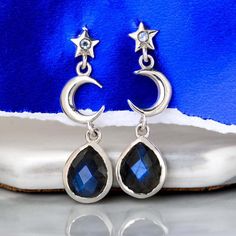 These celestial moon and star sterling silver Labradorite earrings are pure magic! Inspired by the night sky, these earrings feature crescent moons and stars with a stunning genuine Labradorite gem. Wear these on a beautiful night out or let them add a bit of glam to casual outfit. Labradorite can symbolize self-love, spiritual protection and intuition.*Our jewelry features natural, genuine gemstones, ensuring each piece is unique and one-of-a-kind. Please note that, as no two gemstones are iden Celestial Style Pierced Sterling Silver Jewelry, Moon Phase Star Earrings For Gift, Celestial Moon Phase Moon Earrings, Celestial Moon Phase Earrings, Celestial Sterling Silver Jewelry With Matching Earrings, Sterling Silver Celestial Jewelry With Matching Earrings, Celestial Silver Moonstone Earrings, Silver Celestial Gemstone Earrings, Celestial Sterling Silver Drop Earrings