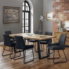 a dining room table with six chairs and a brick wall in the backround