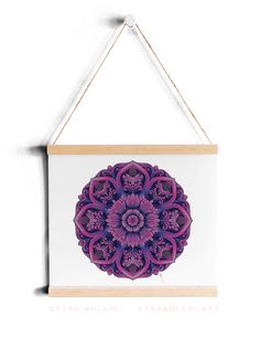 a wooden frame hanging on a wall with a purple and white flower in the center