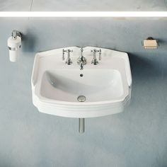 a white sink sitting next to a wall mounted faucet