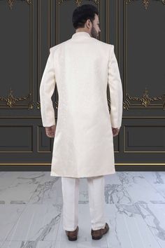 This Mens Sherwani is crafted in brocade, providing a luxurious and elegant touch. The intricate design and high-quality material make it perfect for special occasions and cultural events. Experience high-end fashion and traditional style with our Mens Sherwani - M42-S132. Elegant Jamawar Sherwani With Intricate Embroidery, Elegant Sherwani With Intricate Embroidery In Jamawar, Elegant Beige Sherwani With Chikankari Embroidery, Elegant Cream Bandhgala With Chikankari Embroidery, Cream Chikankari Embroidered Sherwani For Formal Occasions, Cream Sherwani For Groom At Eid, Cream Sherwani For Groom Eid Festival, Formal Cream Nehru Jacket With Chikankari Embroidery, Cream Sherwani For Groom Eid Celebration