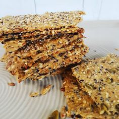 a stack of oatmeal bars sitting on top of a white plate covered in seeds