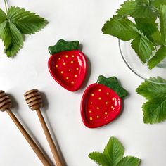 two strawberries are sitting on the table next to honey combs and green leaves