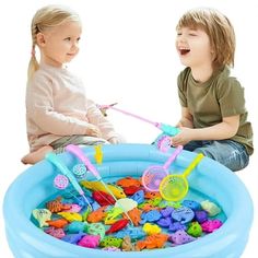 two children playing in an inflatable pool with toys