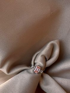 an image of a ring on the back of a dress fabric with a light brown background