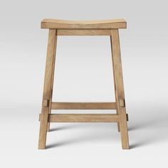 a wooden stool sitting on top of a white floor