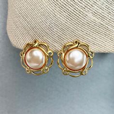 "Vintage Napier Pearl Cabochons Earrings, Gold Tone Cream White Filigree Earrings, Signed Estate Costume Jewelry, Gift for Her. Era: After 1955.  Designer: Napier.  Measurements:      - Length: 1 1/4\" inches.       - Width: 1 1/4\"inches.  Details: - Embellishments: Gold Tone Plating, Cream White Cabochons, filigree round shape Earrings.  - Closure: Push Backs.  Here are more Vintage Jewelry items for your viewing pleasure: https://etsy.me/2SGhTFo Our shop team members do our best to research and identify items correctly and do our best to point out and identify any issues with pieces. Please examine the pictures closely as these are part of the description. Please bear in mind that most of the pieces we offer are vintage and antique and will sometime have some minor wear and character. Y Gold Cabochon Earrings For Wedding, Gold Cabochon Pearl Earrings, Round Metal Cabochon Earrings, Gold Clip-on Earrings With Cabochon For Gift, Elegant Round Cabochon Clip-on Earrings, Gold Cabochon Earrings For Anniversary, Gold Vintage Pearl Earrings Nickel Free, Elegant Nickel-free Plug Earrings For Anniversary, Vintage White Filigree Earrings