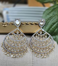 Elevate your look with our Designer Two-Tone Diamond Kundan Chandbali Earrings. This exquisite set features a beautiful combination of gold-plated kundan and sparkling diamonds, perfect for Indian weddings or special occasions. The intricate chandbali design adds a touch of tradition and elegance, making it a stunning addition to any jewelry collection. Shine on your special day with this luxurious piece! Earrings are Approximately 3.2 Inches Long and 1.6 Inches Wide  A Earring Weight is 0.7 oz  Our products are meticulously handcrafted, ensuring each piece is unique. Due to the manual craftsmanship, you may notice slight irregularities, which are natural and do not compromise the quality of the jewelry. Luxury Gold Chandbali Kundan Necklace, Luxury Chandbalis With Intricate Design For Formal Occasions, Luxury Fusion Jewelry Sets With Round Design, Kundan Chandbali, Kundan Necklace Set, Chandbali Earrings, Kundan Necklace, Indian Wedding Jewelry, Indian Weddings