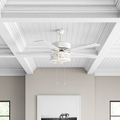 a living room filled with furniture and a white ceiling fan over a couch in front of a window