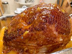 a large cooked turkey in a pan with sauce on the top and sides, ready to be served