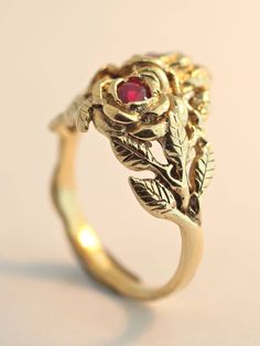 Two detailed roses make up this elegant ring, their stems entwining and forming the band. The ring is cast in solid 14K gold and two 3 mm rubies are set in the center of each rose. Indulge yourself or someone special in this sparkling bouquet. We will contact you to let you know if we have your chosen ring size in stock or when to expect shipment. All Marty Magic Jewelry is packaged in a beautiful ring box embossed with the gold foil Marty Magic dragon logo. Perfect for any occasion! Designed in Elegant 14k Gold Flower Ring With Rose Design, Elegant Gold Rings With Rose Details, Vintage Rose Gold 14k Gold Flower Ring, Vintage 14k Rose Gold Flower Ring, Formal Yellow Gold Flower Ring With Rose Design, Formal Rose Flower Shaped Rings, Formal Rose Flower Rings, Formal Rose Colored Flower Shaped Rings, Vintage Rose Gold Flower Ring For Formal Occasions