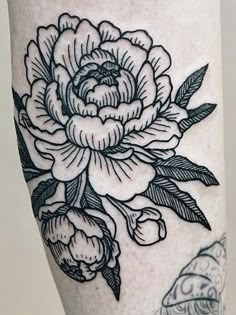 a black and white flower tattoo on the leg