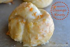 three orange donuts with white frosting and sprinkles