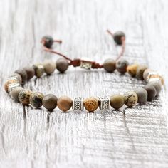 ◈ This beautiful Tibetan bracelet is carefully handcrafted with jasper rhodonite beads and high quality wooden beads. Each bead has been individually selected to ensure beauty and durability. This handcrafted men's bracelet is a versatile accessory that can complement any outfit. The wooden beads used in this bracelet have a rustic, natural charm. Each has a unique pattern and texture, making each bracelet a special and unique piece. These beads are strung on sturdy thread that has been skillful Nature-inspired Adjustable Beaded Bracelet With Round Beads, Adjustable Brown Polished Bead Bracelets, Adjustable Brown Jasper Bracelet, Adjustable Brown Polished Beads Bracelet, Bohemian Jasper Round Bead Bracelets, Adjustable Jasper Beaded Bracelets With Round Beads, Adjustable Jasper Beaded Bracelets, Adjustable Beaded Nature-inspired Bracelet, Adjustable Jasper Jewelry For Healing