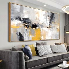 a living room filled with furniture and a large painting hanging on the wall above it