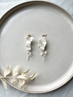 Are you looking for floral bridal earrings? You'll find them here! These earrings made of white ceramic flowers are a real eye-catcher and perfect as bridal jewelry! Stud earrings made of 316L stainless steel jewelry wire Pearls and fine ceramic flowers For more jewelry inspo, check out our shop! You can also find matching hairpins here 🤍 Photos: dark-haired model: Diana Alyasin Blonde model: Janine Klebolte 💫 Handmade Delicate White Pearl Earrings, Delicate Handmade White Bridal Earrings, White Handmade Delicate Bridal Earrings, White Wedding Jewelry With Flower Decoration, White Bridal Jewelry With Matching Earrings, White Flower Decoration Wedding Jewelry, Delicate White Jewelry With 3d Flowers, Flower-shaped White Jewelry For Wedding, Delicate White Pearl Earrings In Flower Shape