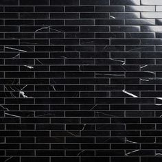 a black and white photo of a man's face on a brick wall