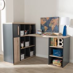 a corner desk with bookshelves, lamp and pictures on the wall behind it