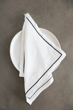 two white napkins sitting on top of a white plate