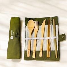 wooden utensils are in a green case on a white surface with a zippered pouch