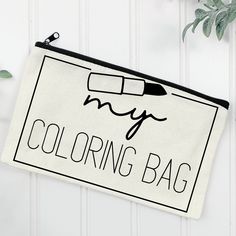 a black and white bag with the words coloring bag on it next to a plant