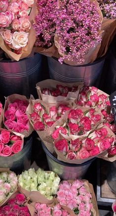 several buckets filled with pink and white flowers